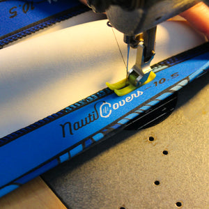 Up close view of live manufacturing sewing of blue NautiCovers branded boat fender cover