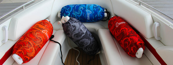 Vibrant group of boat fender covers in boat front bow including Blue, Orange, Red and Grey with NautiCovers branded Logos